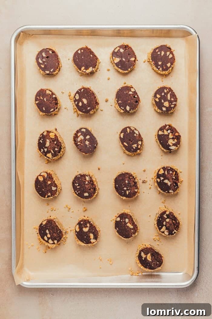 Unbaked chocolate slice and bake cookies perfectly arranged on a parchment-lined baking sheet.