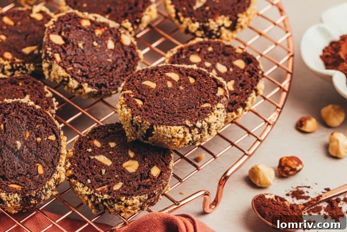A close-up view of chocolate hazelnut shortbread cookies cooling on a metal rack.