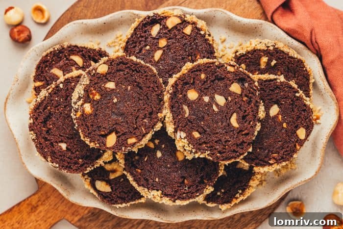 A single plate holding several chocolate slice and bake cookies, ready to be eaten.