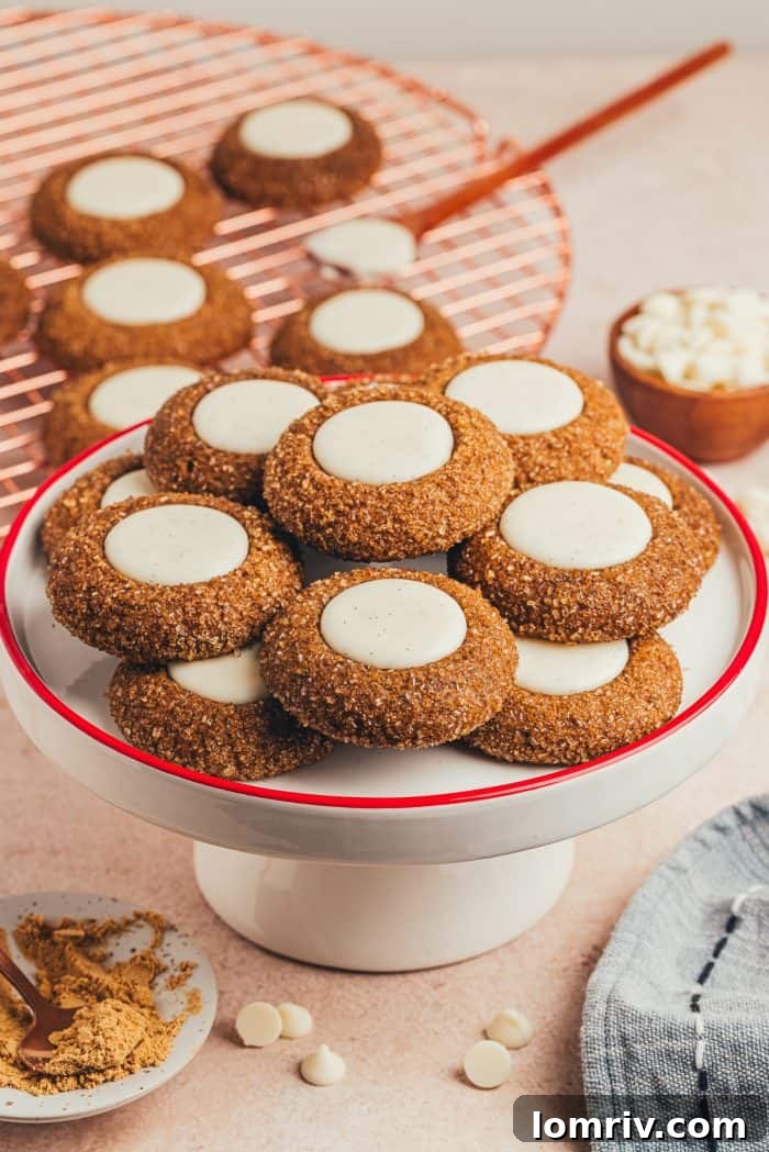 A cake stand with a variety of gingerbread thumbprint cookies.