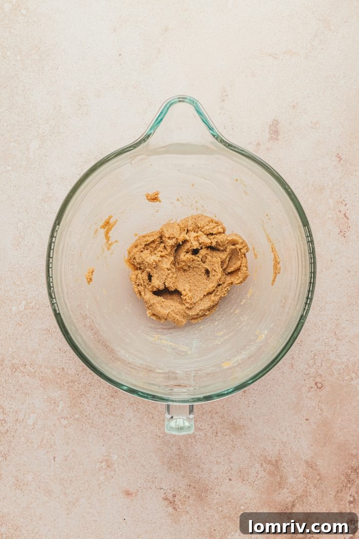 The butter and sugar beat together in a glass bowl.