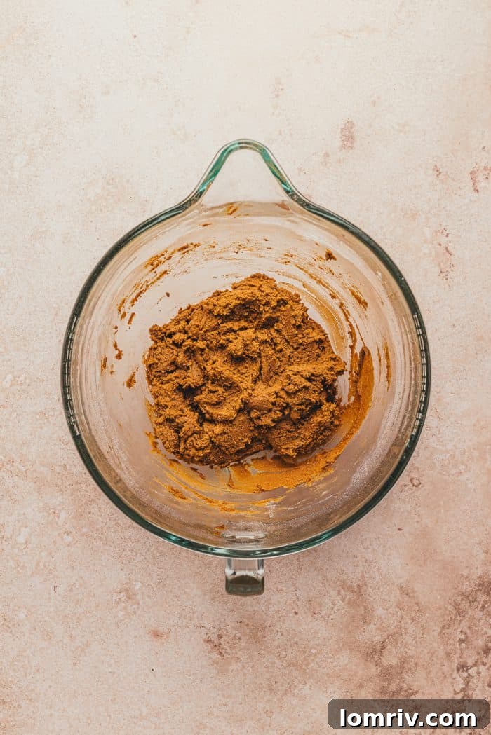 Gingerbread thumbprint dough mixed together in a glass mixing bowl.