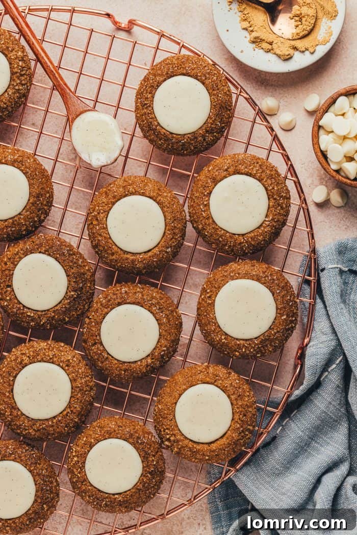 A variety of gingerbread thumbprint cookies on a cooling rack. 