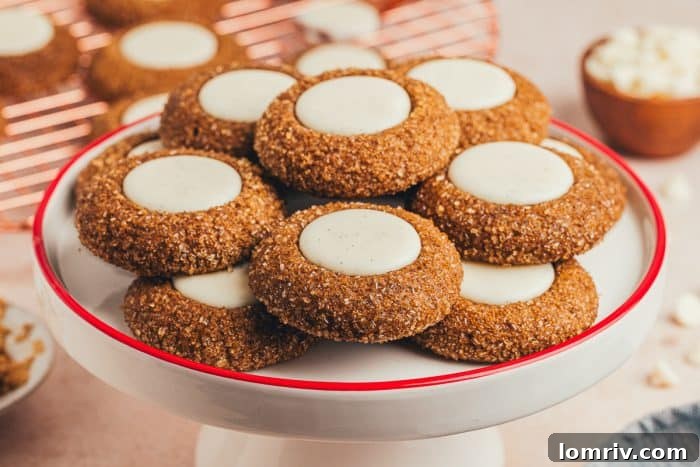 A cake stand with a variety of gingerbread thumbprint cookies.