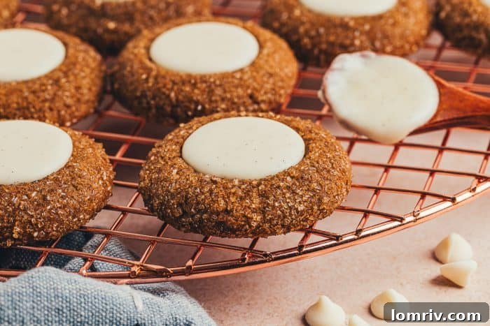 A variety of gingerbread thumbprint cookies on a cooling rack.