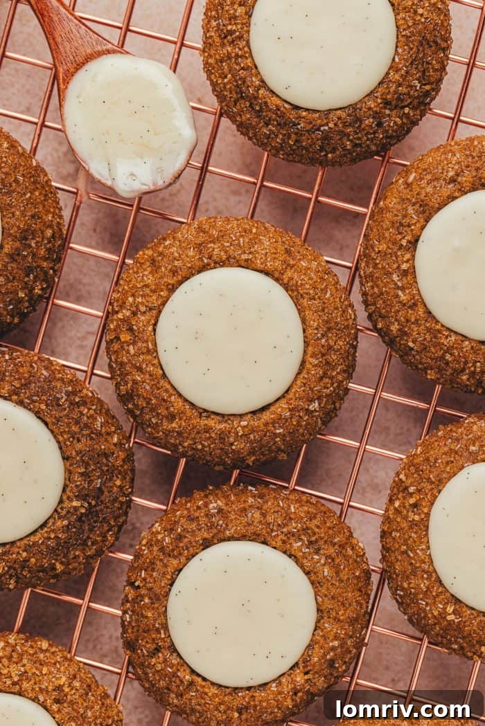 A variety of gingerbread thumbprint cookies on a cooling rack.