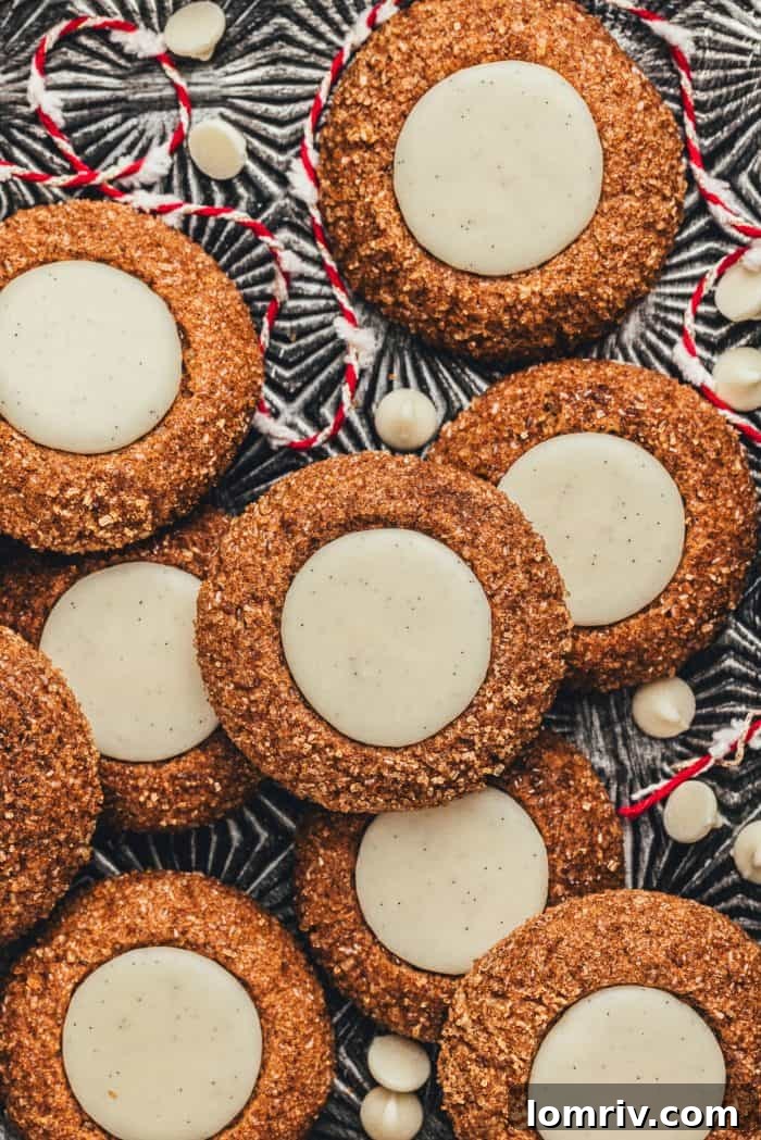 A platter with a variety of gingerbread thumbprint cookies and red and white string.