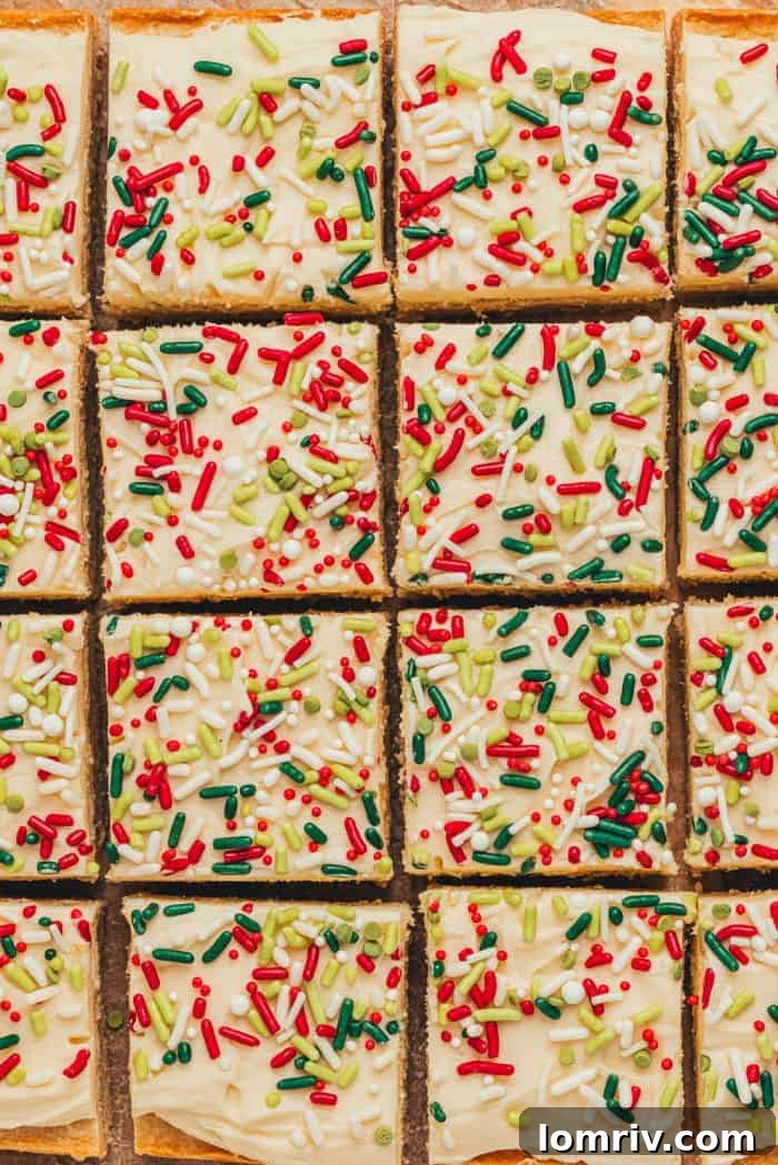 Frosted sugar cookie bars sliced showing the top of the bar with sprinkles.