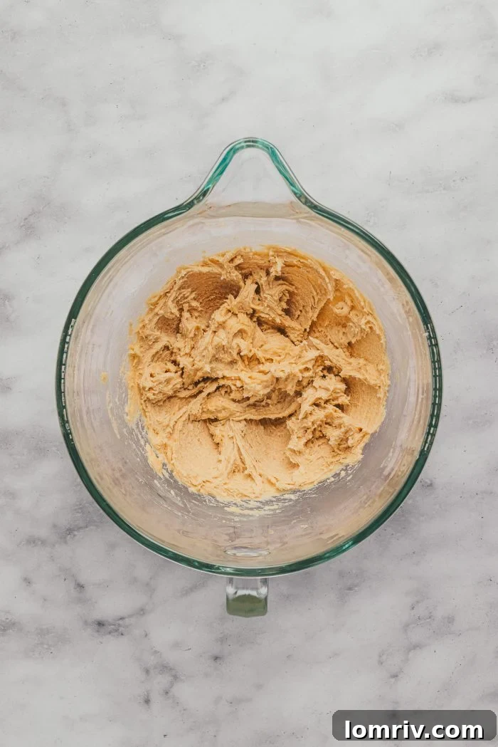 A glass mixing bowl with the batter to make sugar cookie bars.