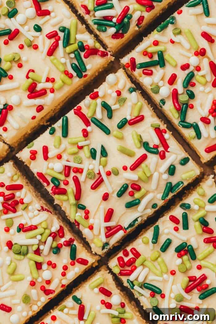 Frosted sugar cookie bars sliced showing the top of the bar with sprinkles.