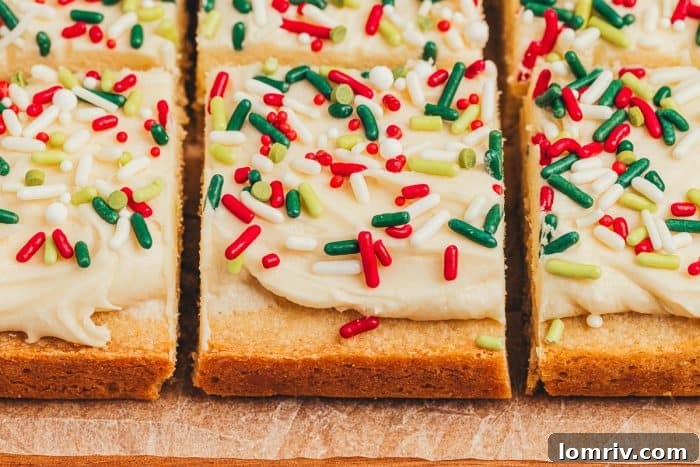 Frosted sugar cookie bars sliced showing the top of the bar with sprinkles.