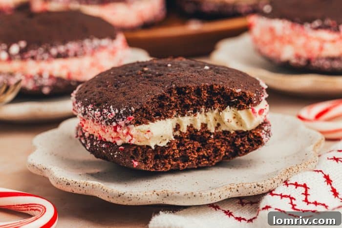 A delectable chocolate peppermint whoopie pie with a bite taken out, resting on a plate, showcasing its fluffy interior.