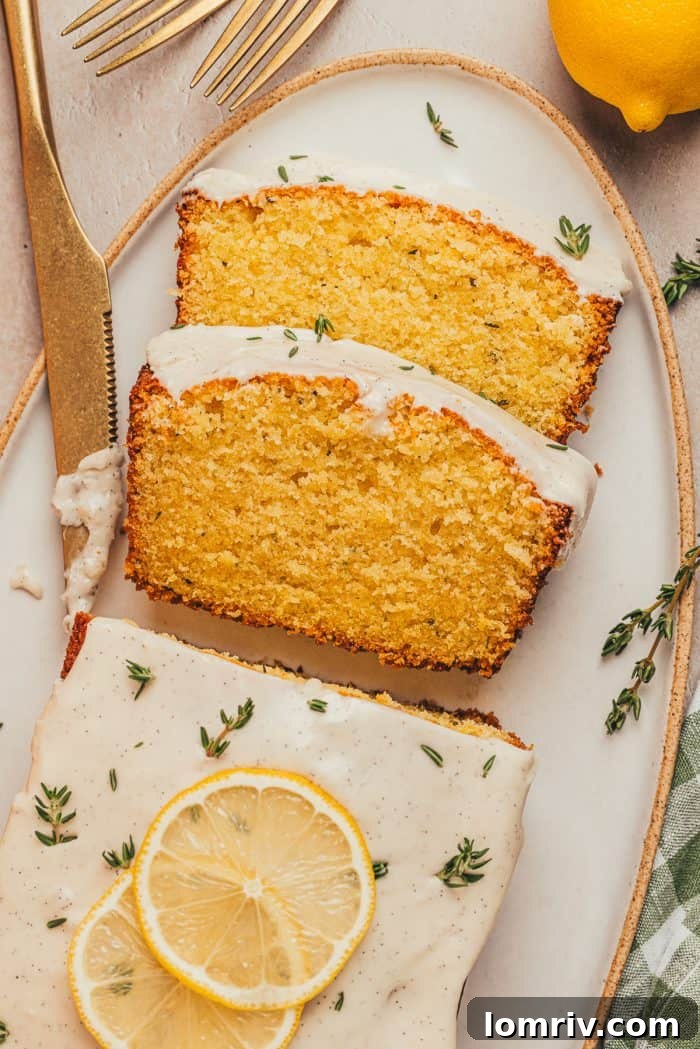 A beautifully arranged platter showcasing a golden-brown lemon pound cake loaf, with several slices neatly cut and fresh thyme sprigs delicately sprinkled around it, inviting a delicious tasting.