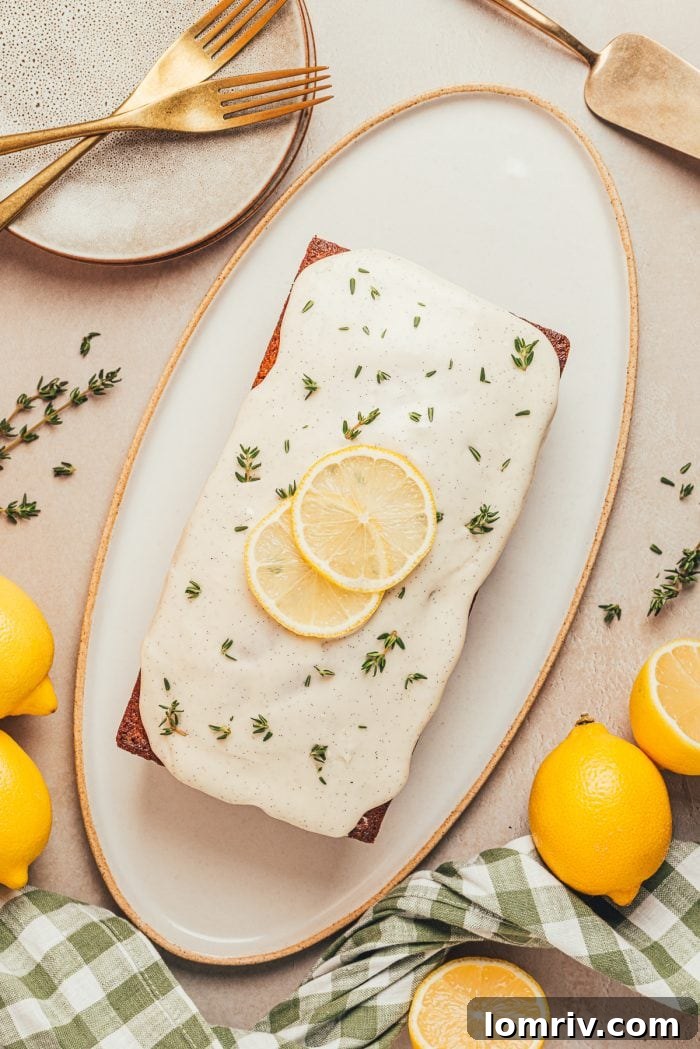 A pristine loaf of lemon pound cake, perfectly baked to a golden hue, presented simply on a white platter, highlighting its classic elegance.
