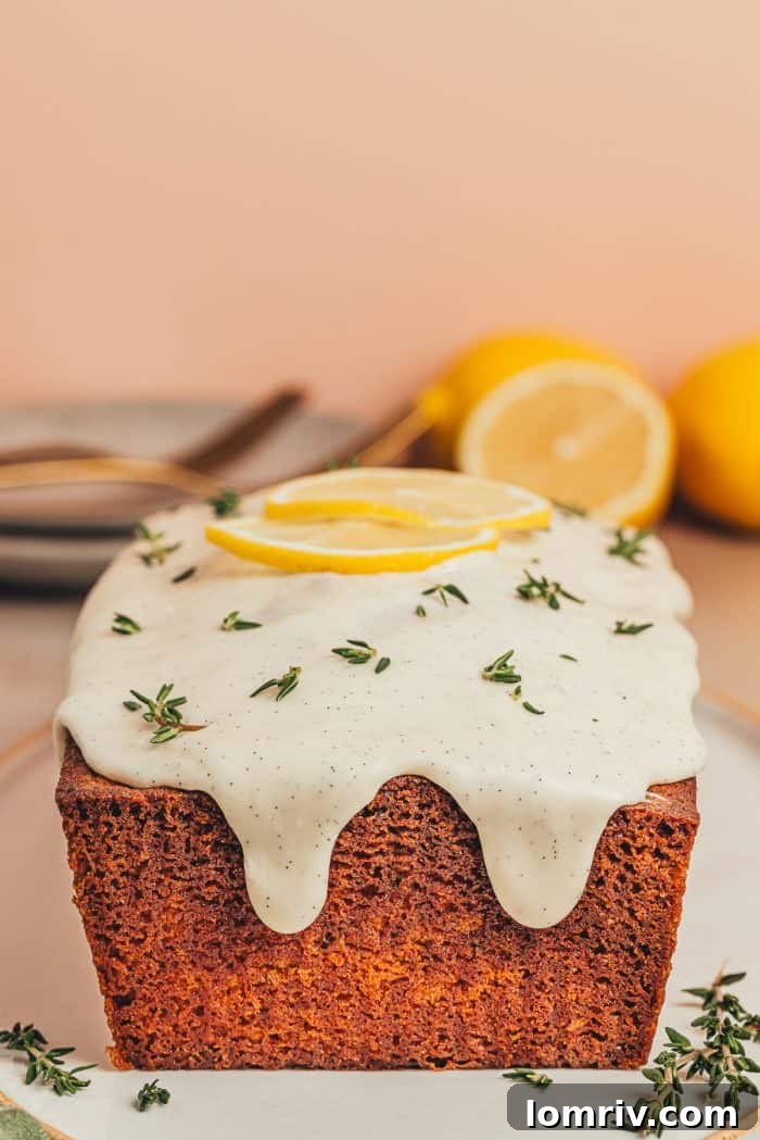 A pristine, unadorned lemon pound cake loaf sits elegantly on a white platter, inviting decoration or slicing.