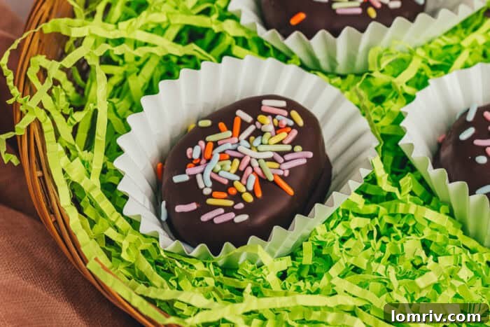 A few homemade chocolate-covered Easter eggs in confetti papers in a wicker basket with shredded green filling.