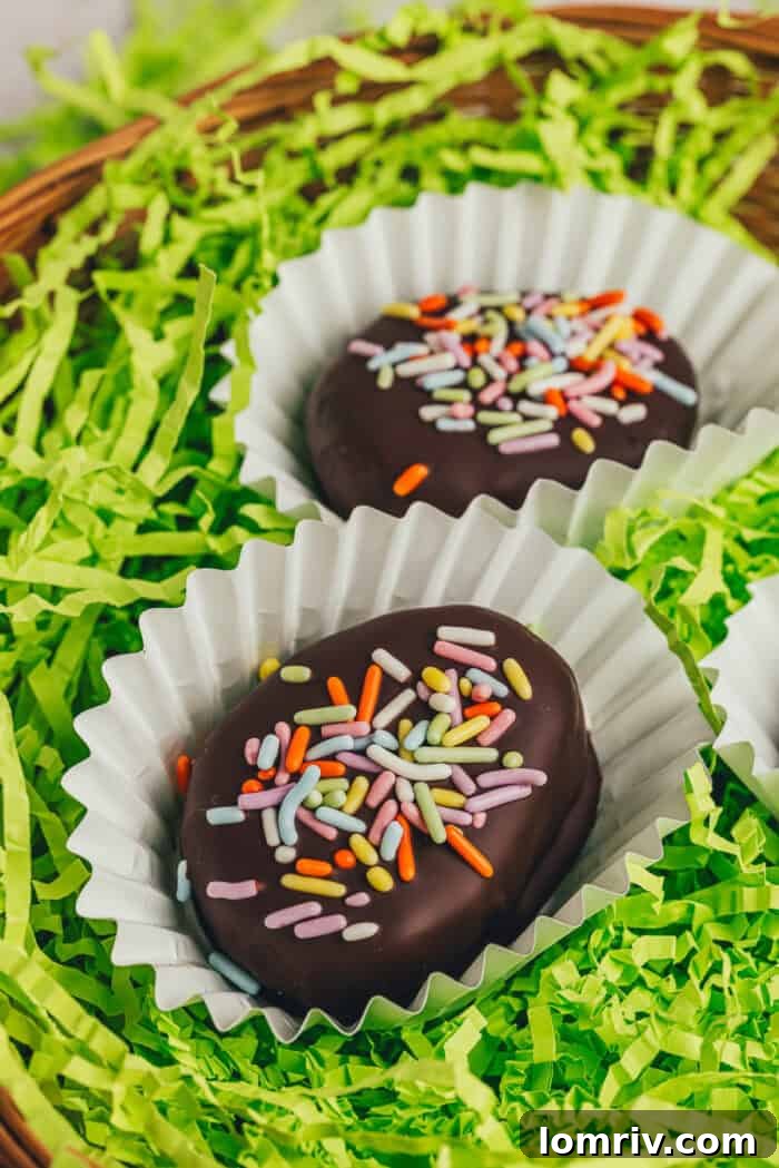 A few homemade chocolate-covered Easter eggs in confetti papers in a wicker basket with shredded green filling.