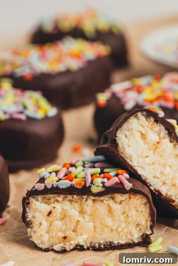 A few homemade chocolate Easter eggs scattered on parchment paper and one egg is split in half.