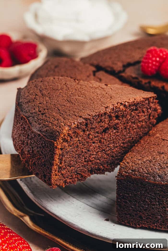 A close-up shot of a slice of the tender chocolate ricotta cake, revealing its delicate crumb texture as it's lifted from the plate.