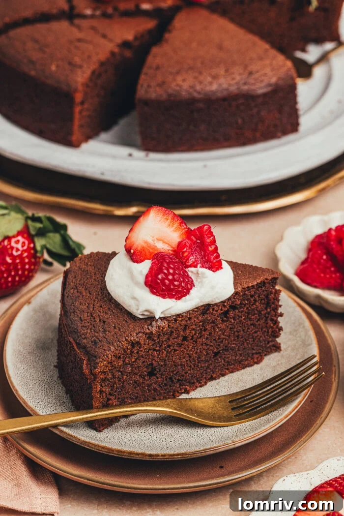 An appetizing slice of rich chocolate ricotta cake, garnished with a cloud of whipped cream and a handful of juicy berries, offering a delightful visual treat.