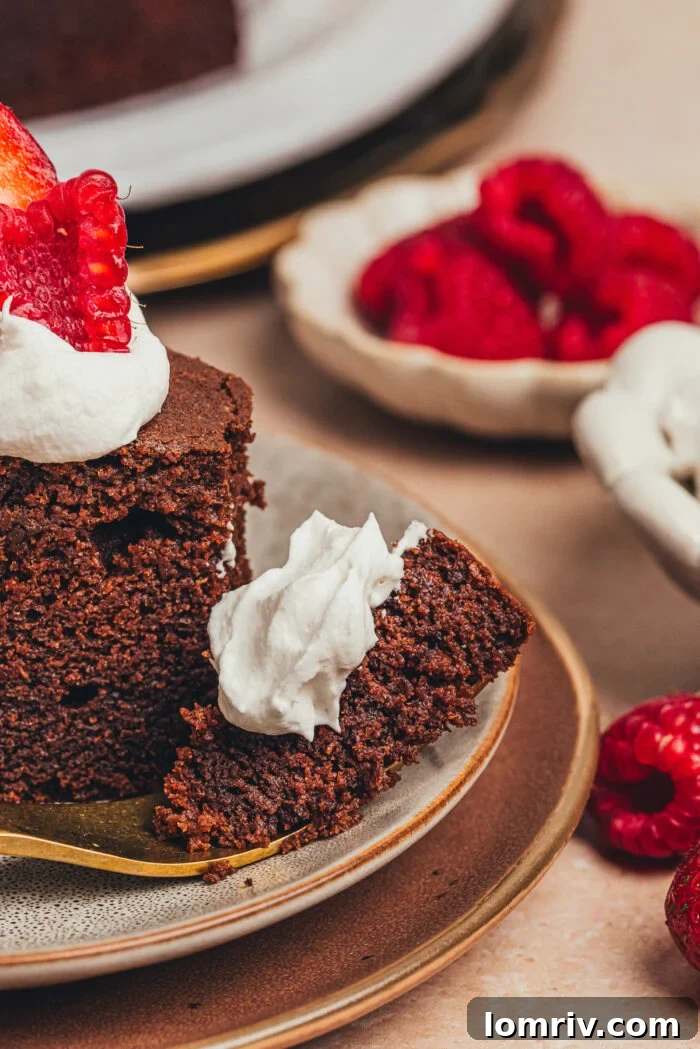 A delicious slice of chocolate ricotta cake with whipped cream and fresh berries, with a bite playfully taken, inviting you to enjoy its rich flavor.
