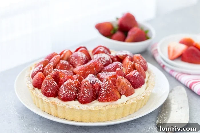 A stunning slice of the strawberry mascarpone tart, revealing its three distinct layers: the buttery crust, creamy filling, and fresh fruit topping.