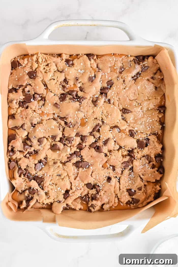 Topping caramel layer with remaining cookie dough and sea salt