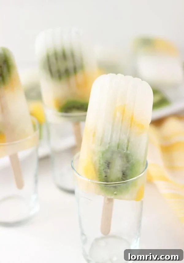 Delicious and vibrant mango kiwi lemonade popsicles on a white background, ready to be enjoyed as a summer treat.