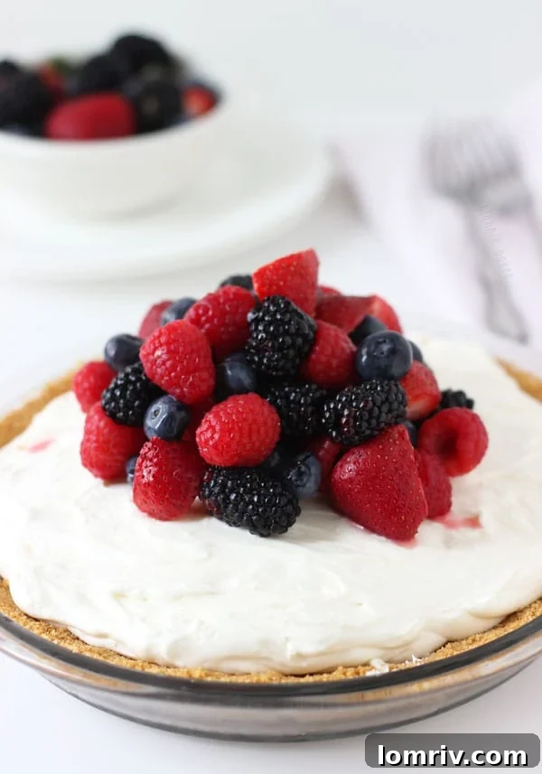 Lush White Chocolate Cheesecake Pie adorned with fresh red and blue berries
