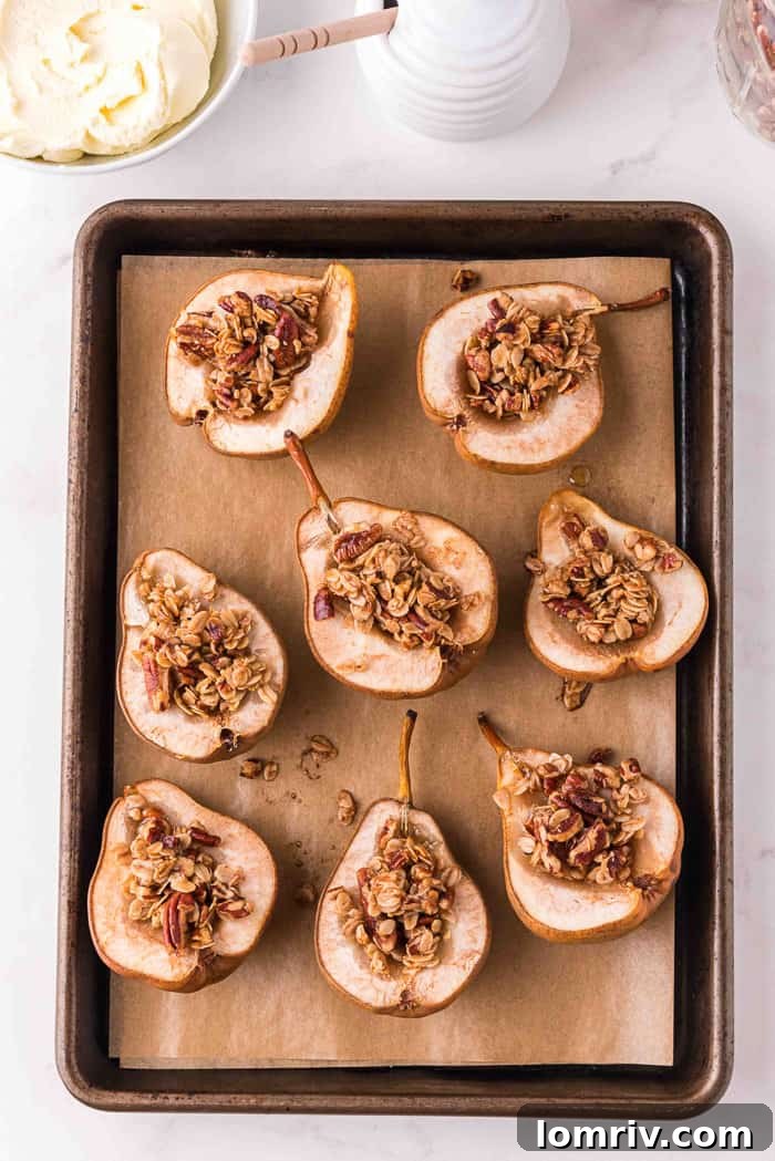 Baked pears on a cookie sheet, golden brown with cooked oat crumble