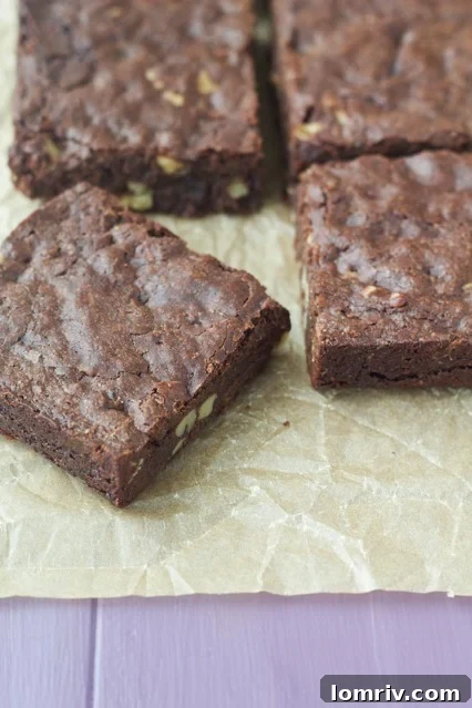 Close-up of a perfectly baked Brown Butter Walnut Brownie, showcasing its chewy texture and generous walnut pieces.