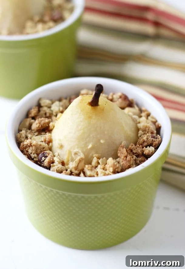 A bowl of Spiced Poached Pear Crumble with a scoop of melting vanilla ice cream