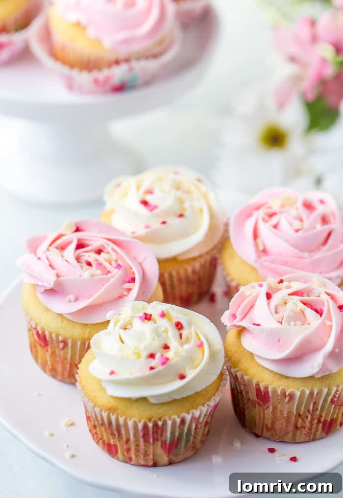 Exquisitely decorated White Chocolate Rose Cupcakes with delicate frosting swirls and a hint of rose petals.