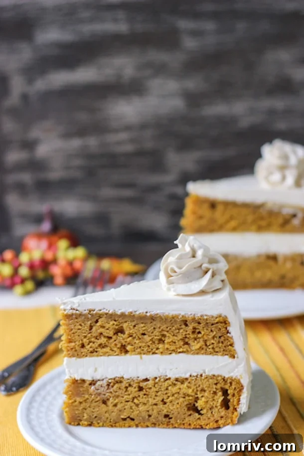 A close-up view of a beautifully sliced Spiced Pumpkin Cake, generously frosted with rich brown sugar frosting and garnished, showcasing a decadent Thanksgiving dessert.