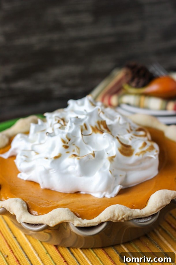 A perfectly baked Sweet Potato Pie crowned with a golden, toasted maple marshmallow topping, offering an inviting and unique Thanksgiving dessert option.