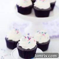 Purple velvet cupcakes with cream cheese frosting and sprinkles.