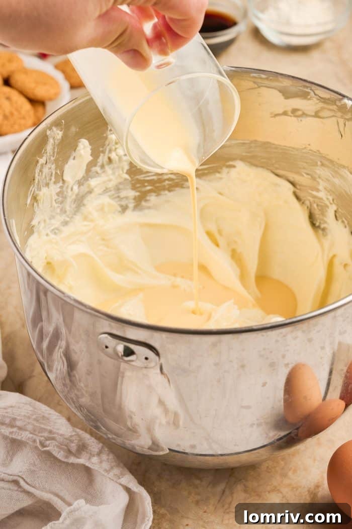 Eggnog cheesecake filling being mixed in a bowl.