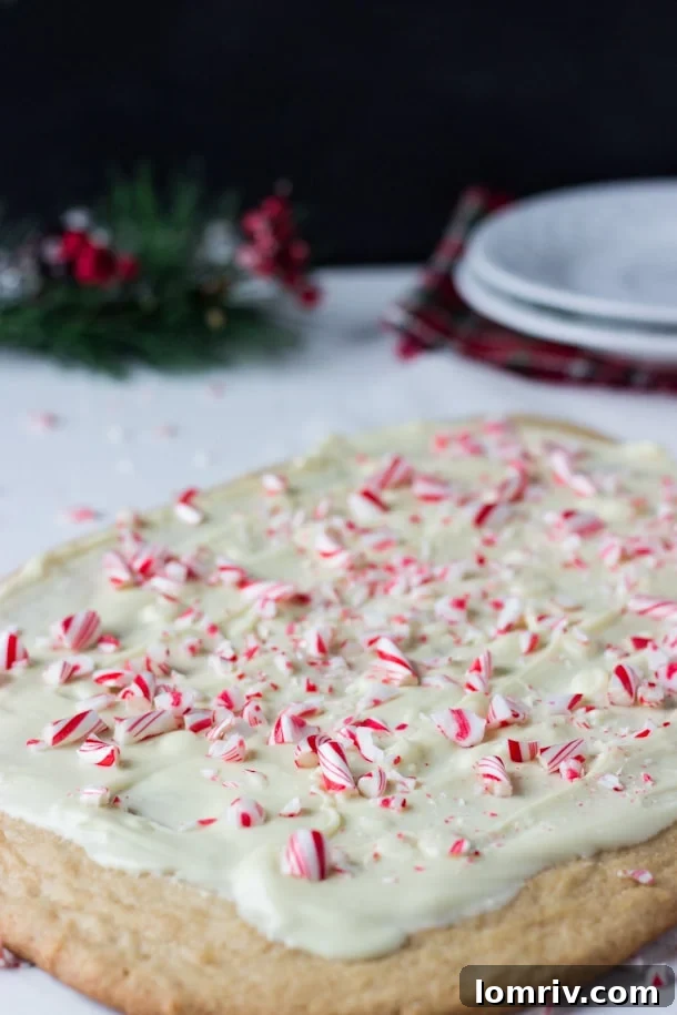 Festive Peppermint Spiced Cookie Bark on a wooden board, showcasing its vibrant red and white toppings.
