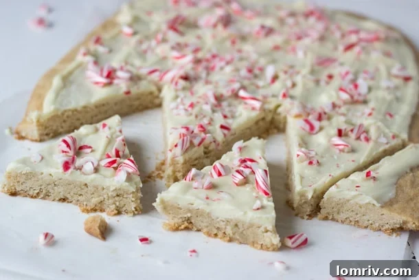 Close-up of freshly made Peppermint Spiced Cookie Bark, showing the melted white chocolate and candy cane pieces.