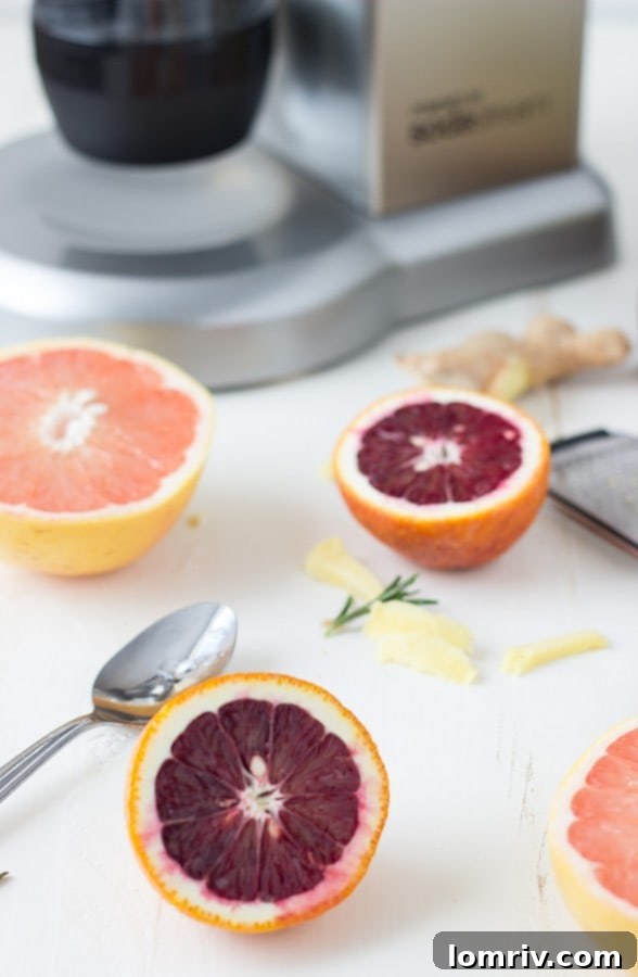 A selection of fresh ingredients including grapefruit, rosemary, and ginger, laid out on a table, ready for preparing sparkling grapefruit cocktails.