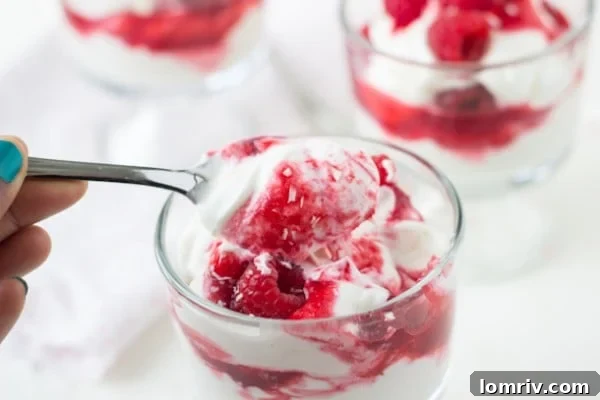 Close-up of a White Chocolate Raspberry Parfait, showing layers of mousse and raspberry swirl
