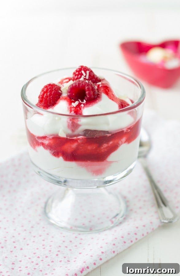 Another perspective of a White Chocolate Raspberry Parfait, showcasing its elegant layers and garnishes