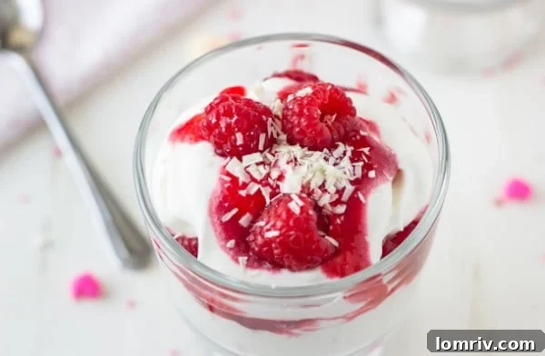 A final close-up of a White Chocolate Raspberry Parfait, garnished with fresh raspberries and chocolate shavings