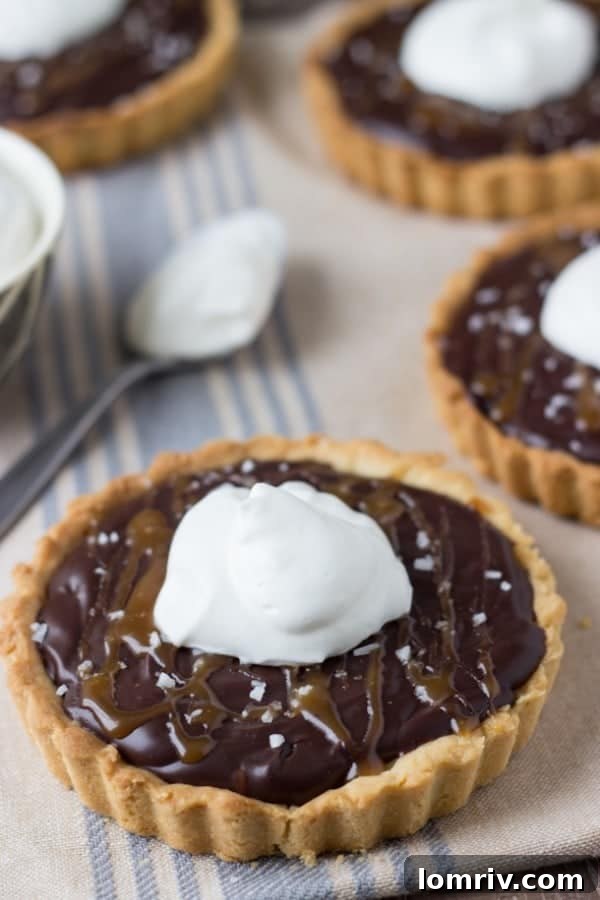 Caramelized Dark Chocolate Tart, top view with a slice removed, showing rich chocolate filling and caramel drizzle.