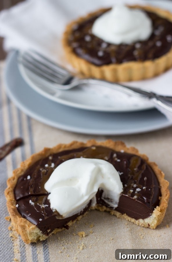 Caramelized Dark Chocolate Tart, presented as a single mini tart with a rich, dark filling.
