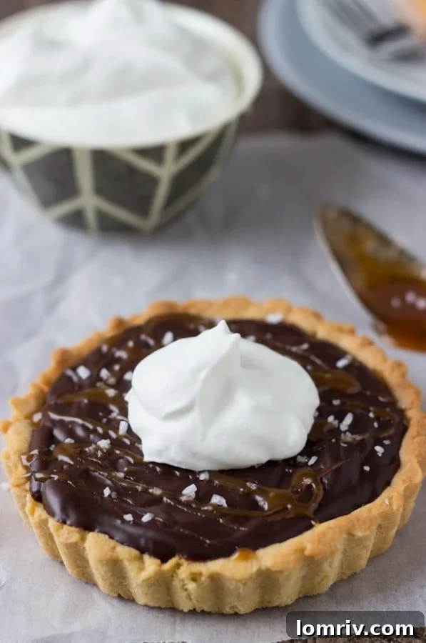 Caramelized Dark Chocolate Tart, featuring a glossy ganache and hints of caramel and sea salt.