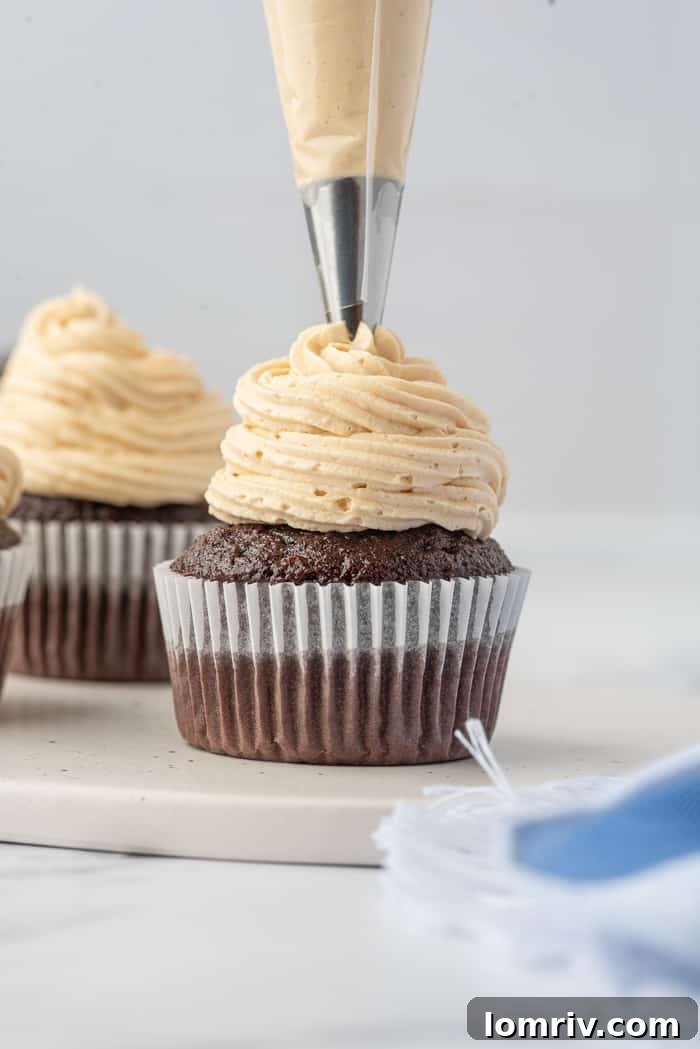 Chocolate Cupcakes being piped with Peanut Butter Buttercream
