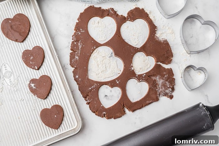 Cutting heart shapes from chocolate cookie dough
