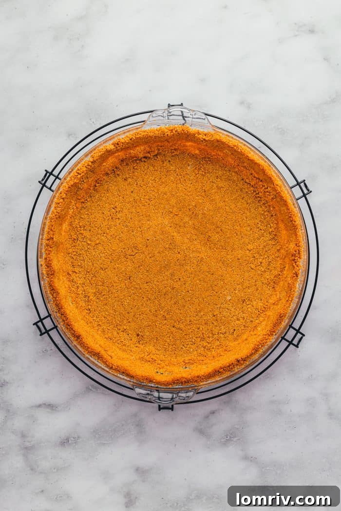 A freshly baked graham cracker crust, golden brown and cooling on a wire rack.