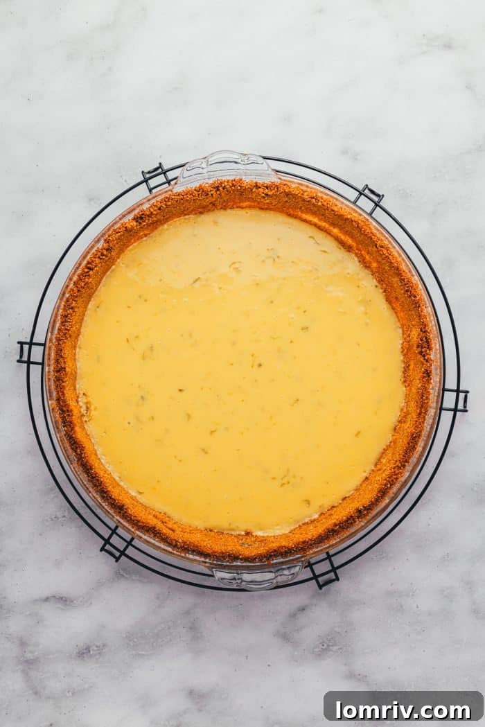 A freshly baked Key Lime Pie, cooling on a rack, its surface gently set and ready for chilling.